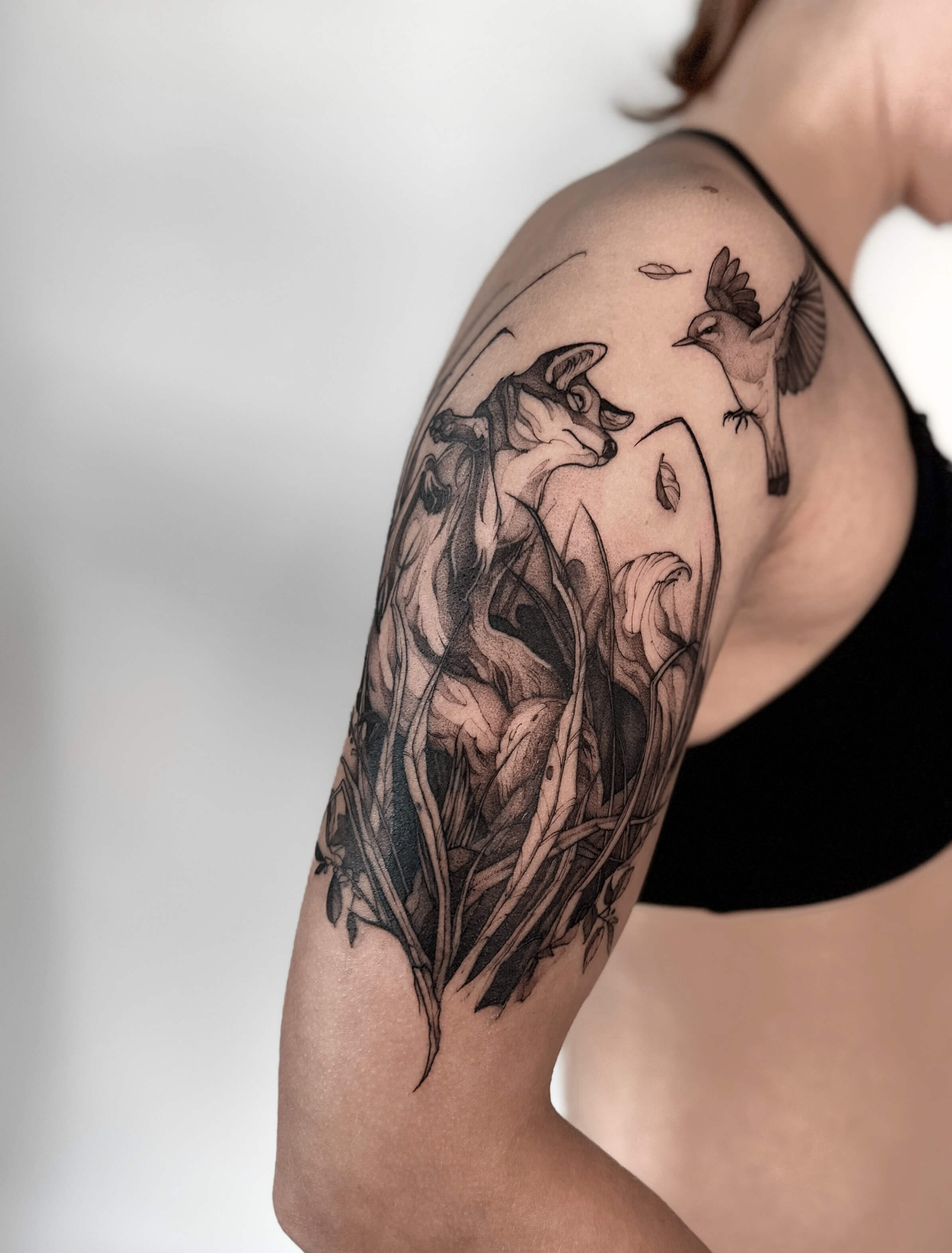 Sketch tattoo of fox and bird among botanical foliage on shoulder — tattoo Barcelona